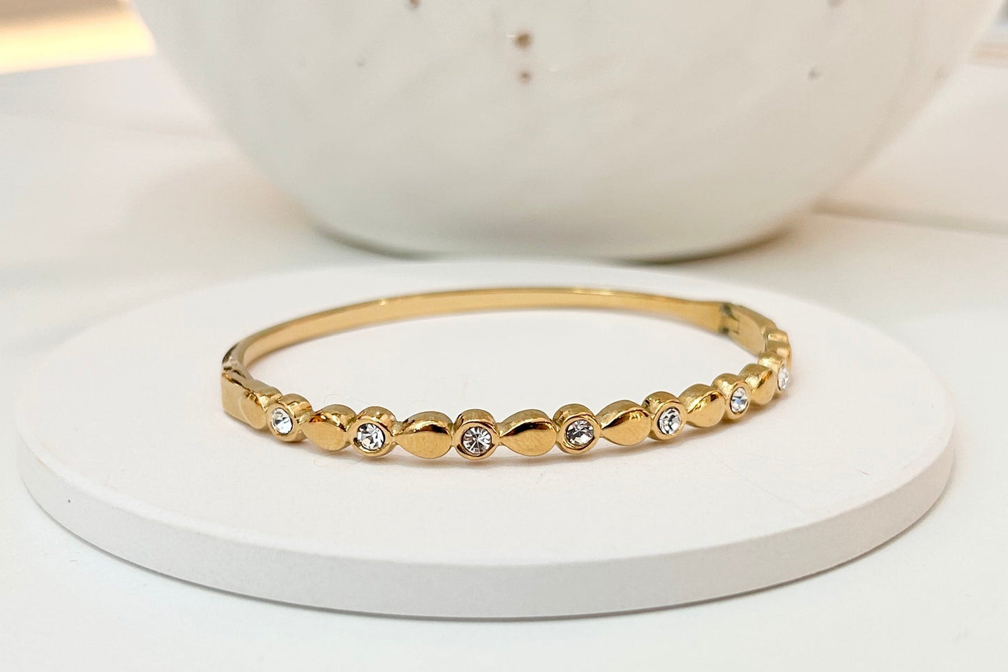 
                  
                    Aurette Gold Beaded Crystal Bangle displayed on a white stand
                  
                