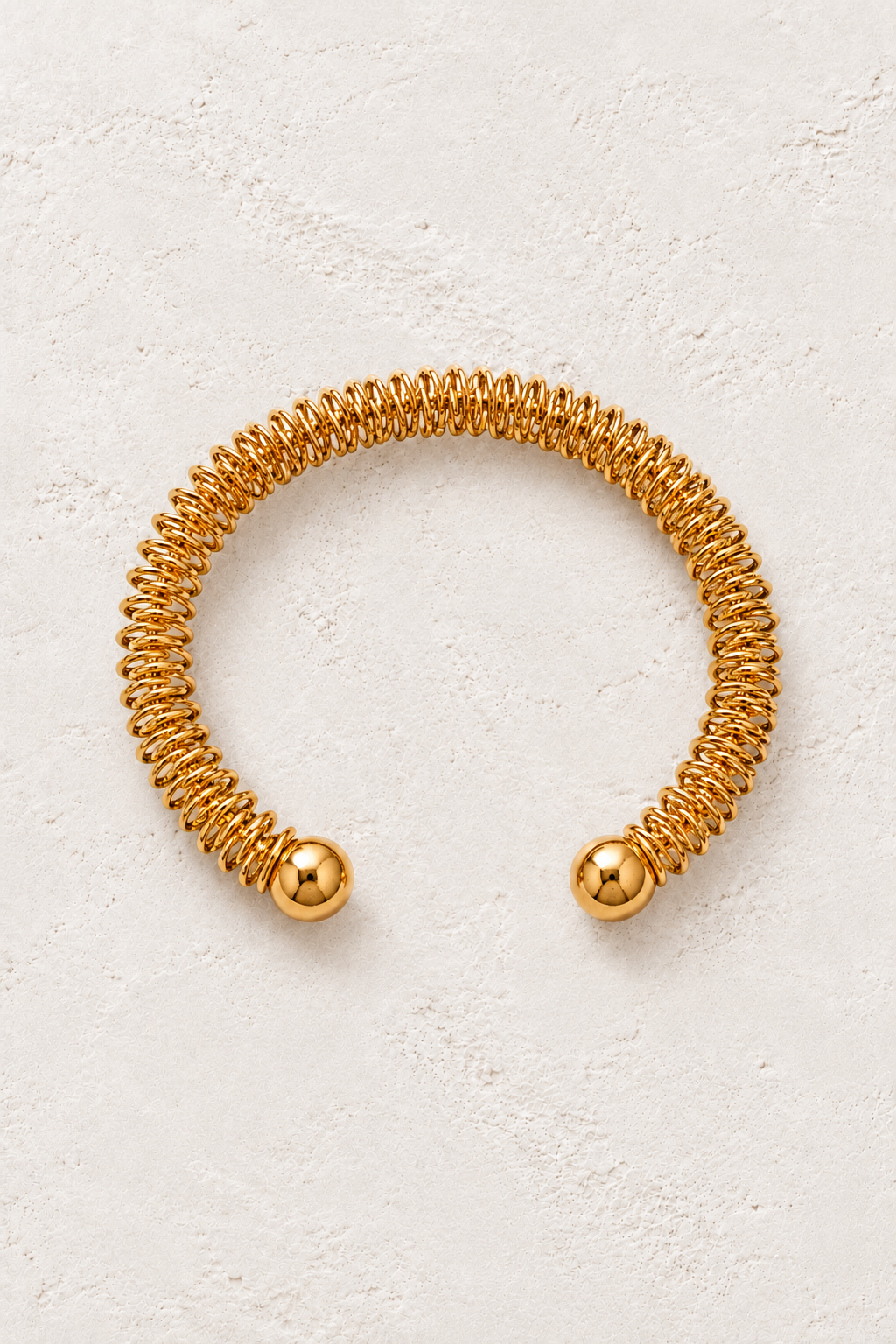 Gold Coil Open Cuff Bracelet | Waterproof on warm ivory plaster