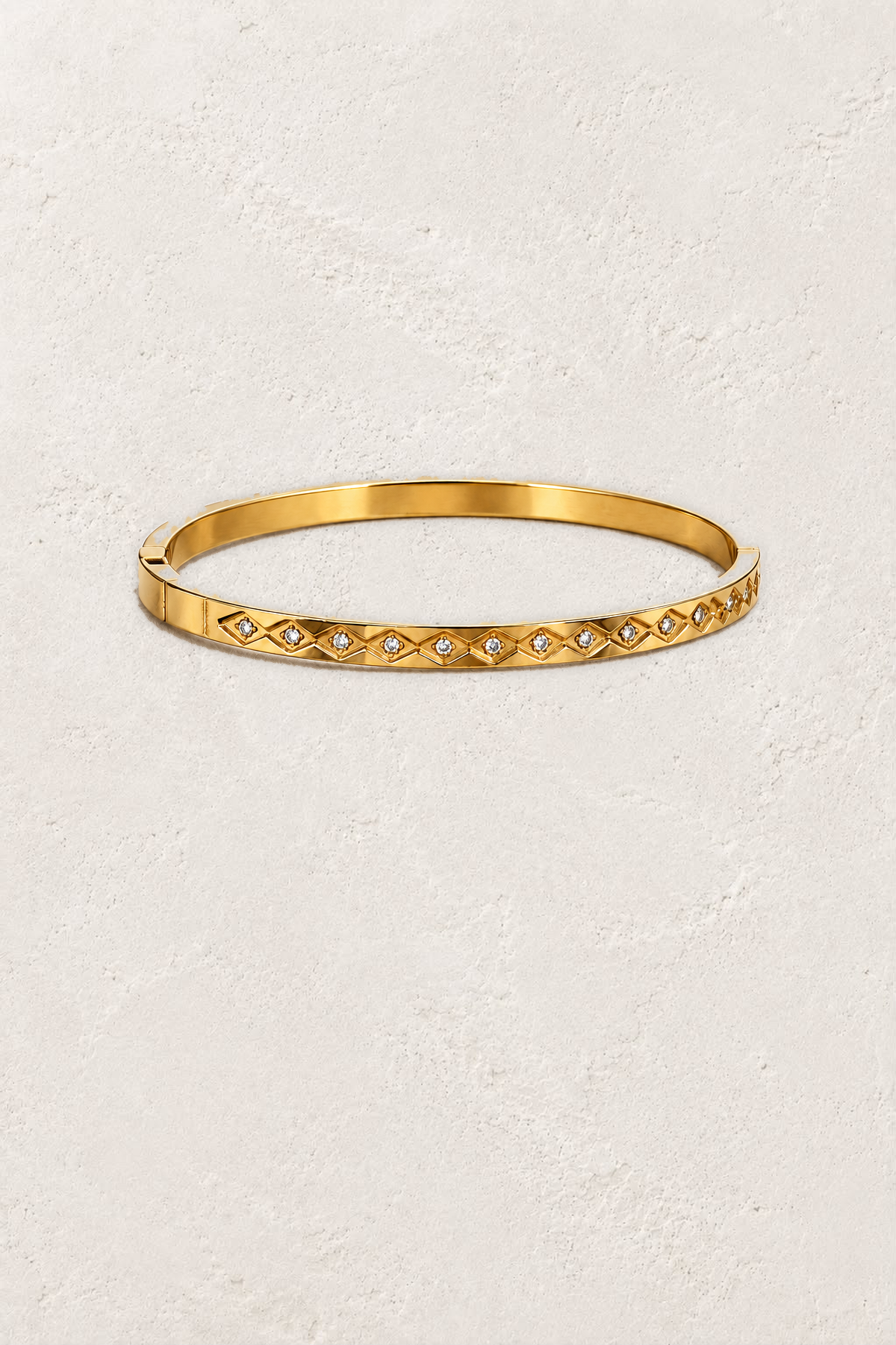 Aster Gold Diamond Motif Bangle on the reference plaster background