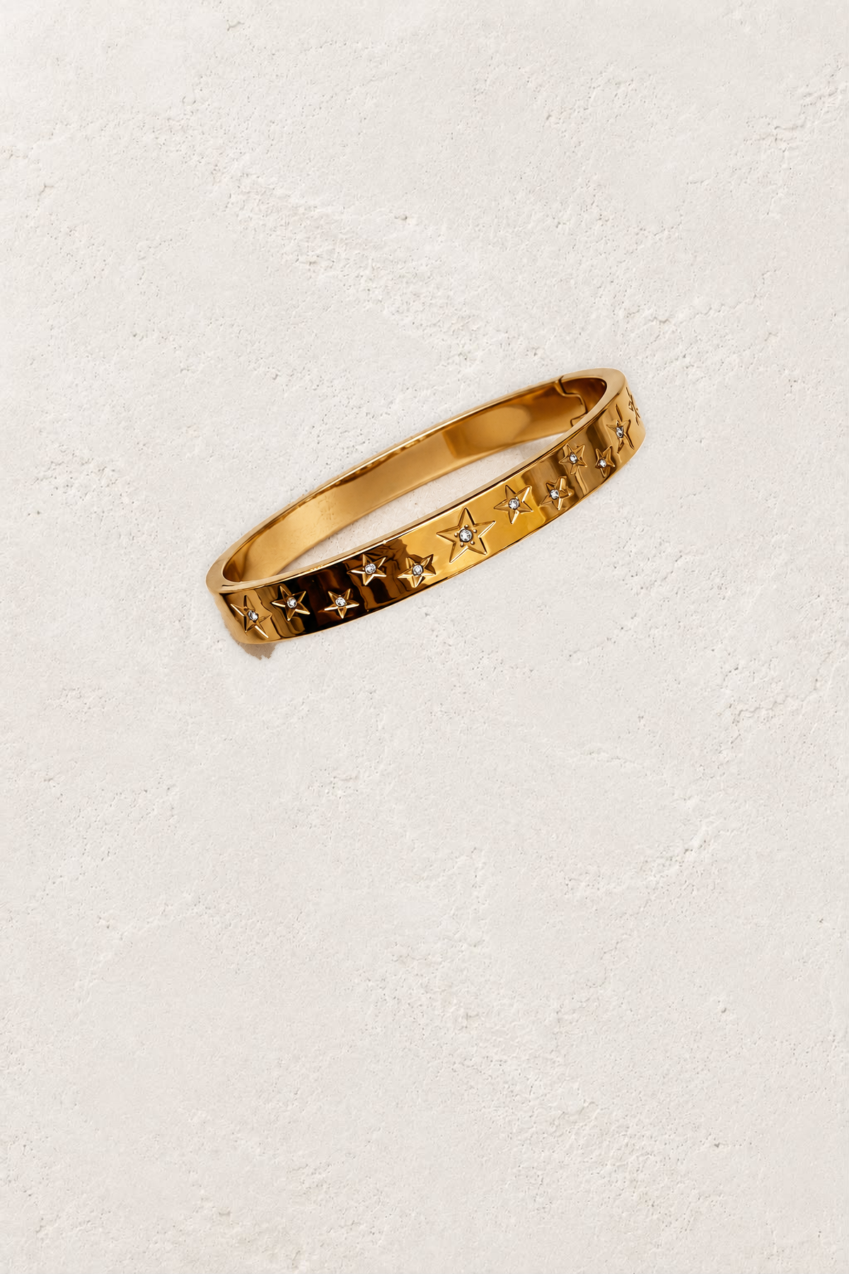 Astra Gold Celestial Bangle on the reference plaster background