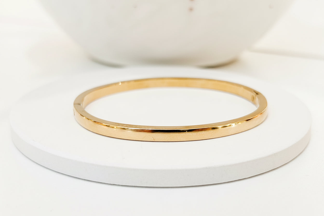 
                  
                    Sorella Classic Polished Gold Bangle displayed on a white stand
                  
                