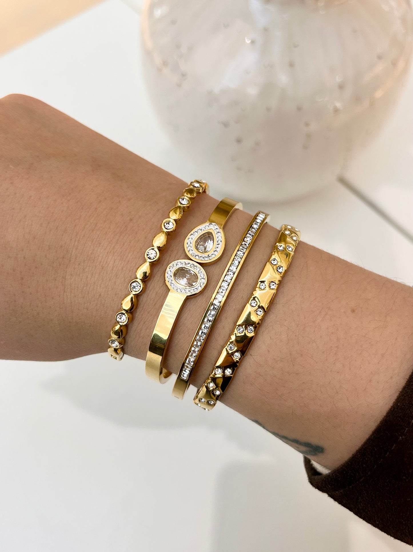 
                  
                    Stack of Boho & Mala waterproof gold bangles worn on a model's wrist
                  
                