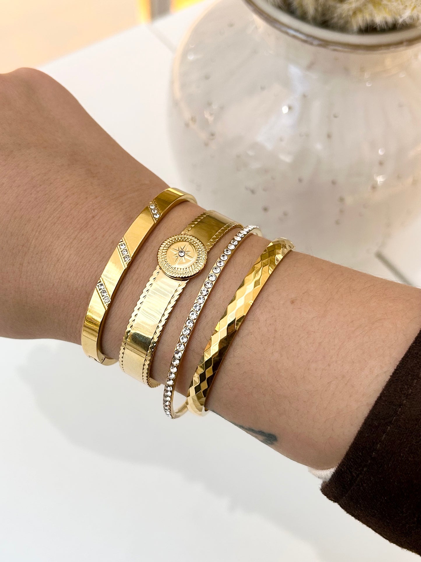 
                  
                    Stack of Boho & Mala waterproof gold bangles worn on a model's wrist
                  
                