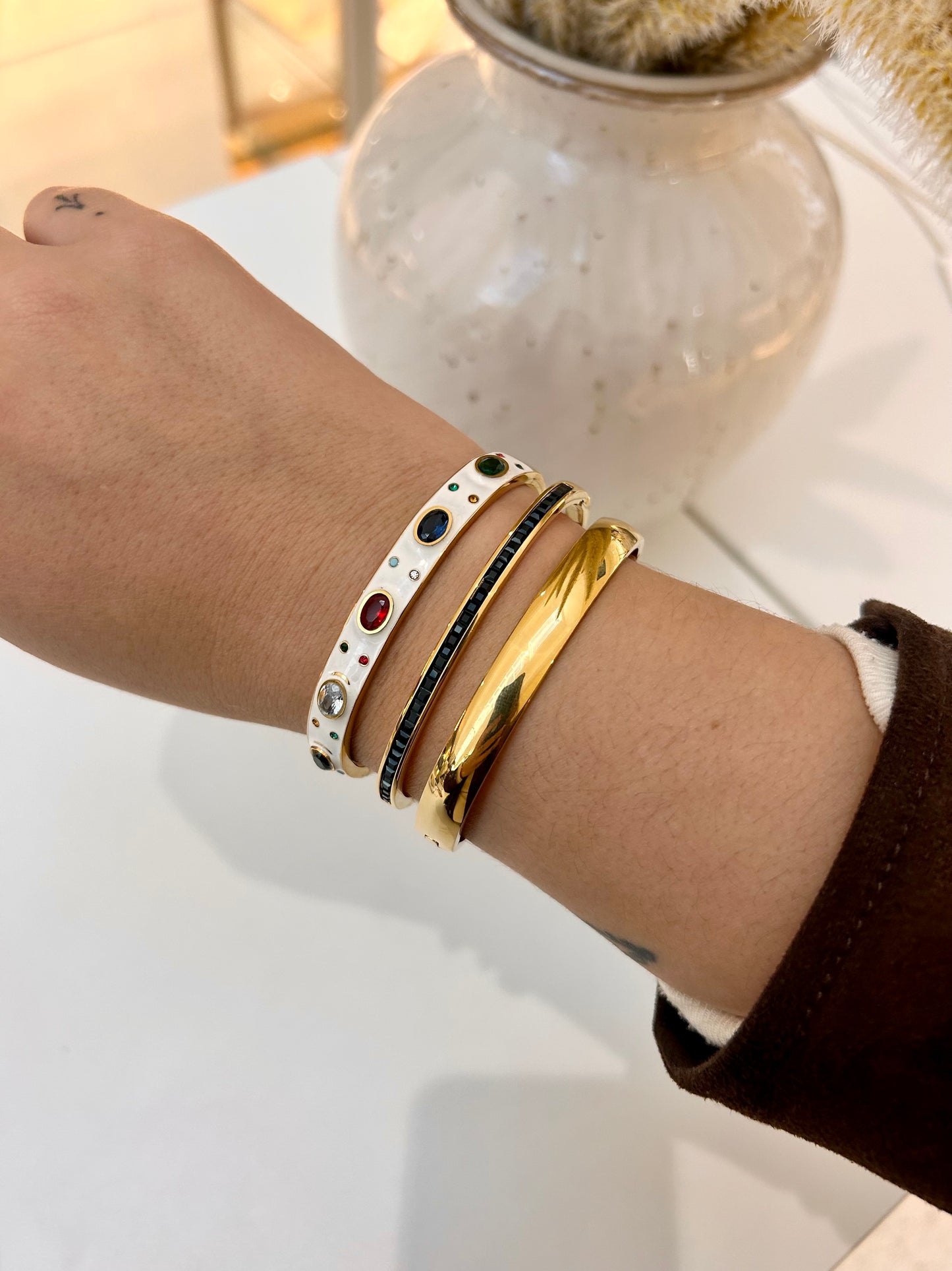 
                  
                    Stack of Boho & Mala waterproof gold bangles worn on a model's wrist
                  
                