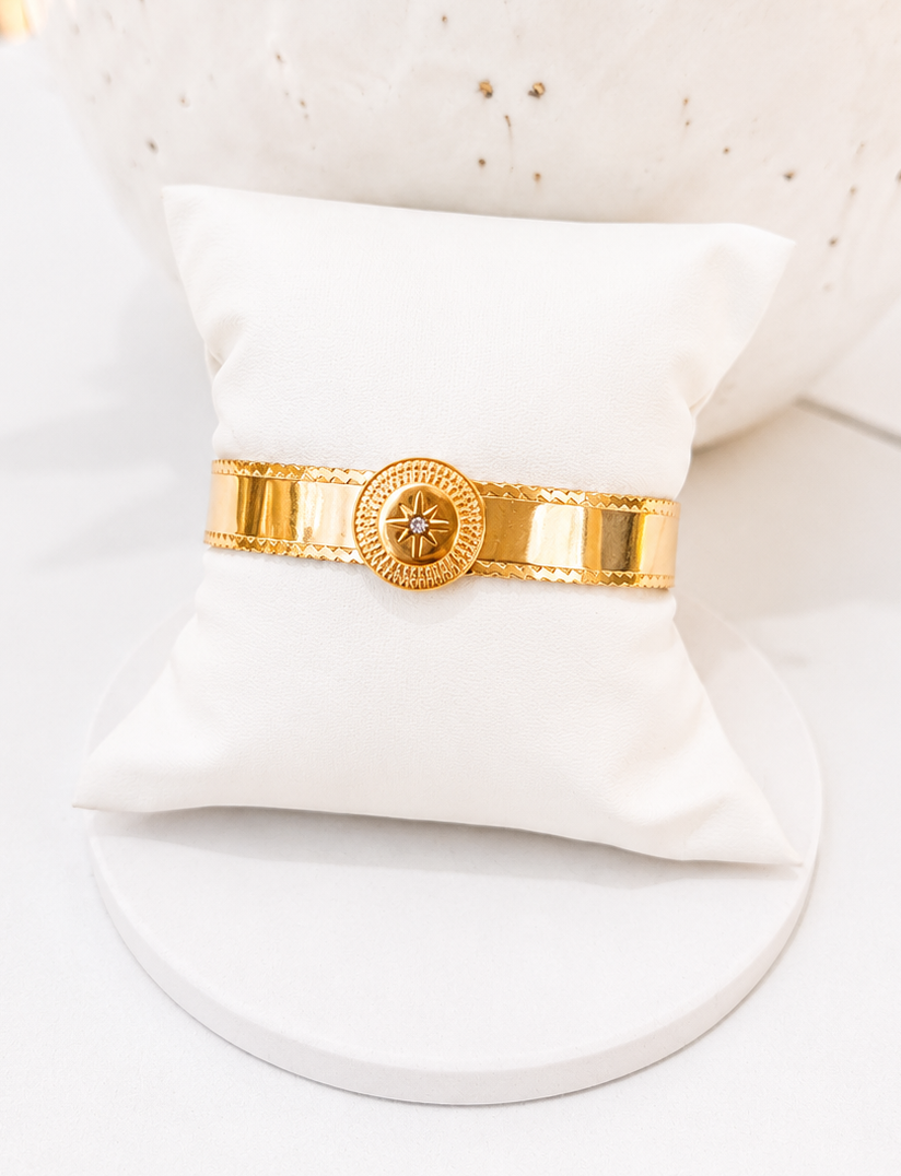 
                  
                    Close-up of the Asterelle Brushed Gold Sun Medallion Cuff
                  
                