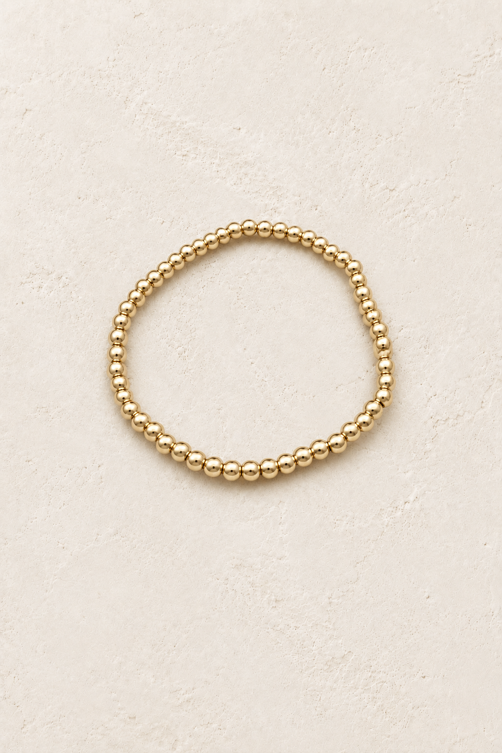 
                  
                    4mm Gold Plated Beaded Elastic Bracelet TF on Boho & Mala's cream beige textured hero background
                  
                