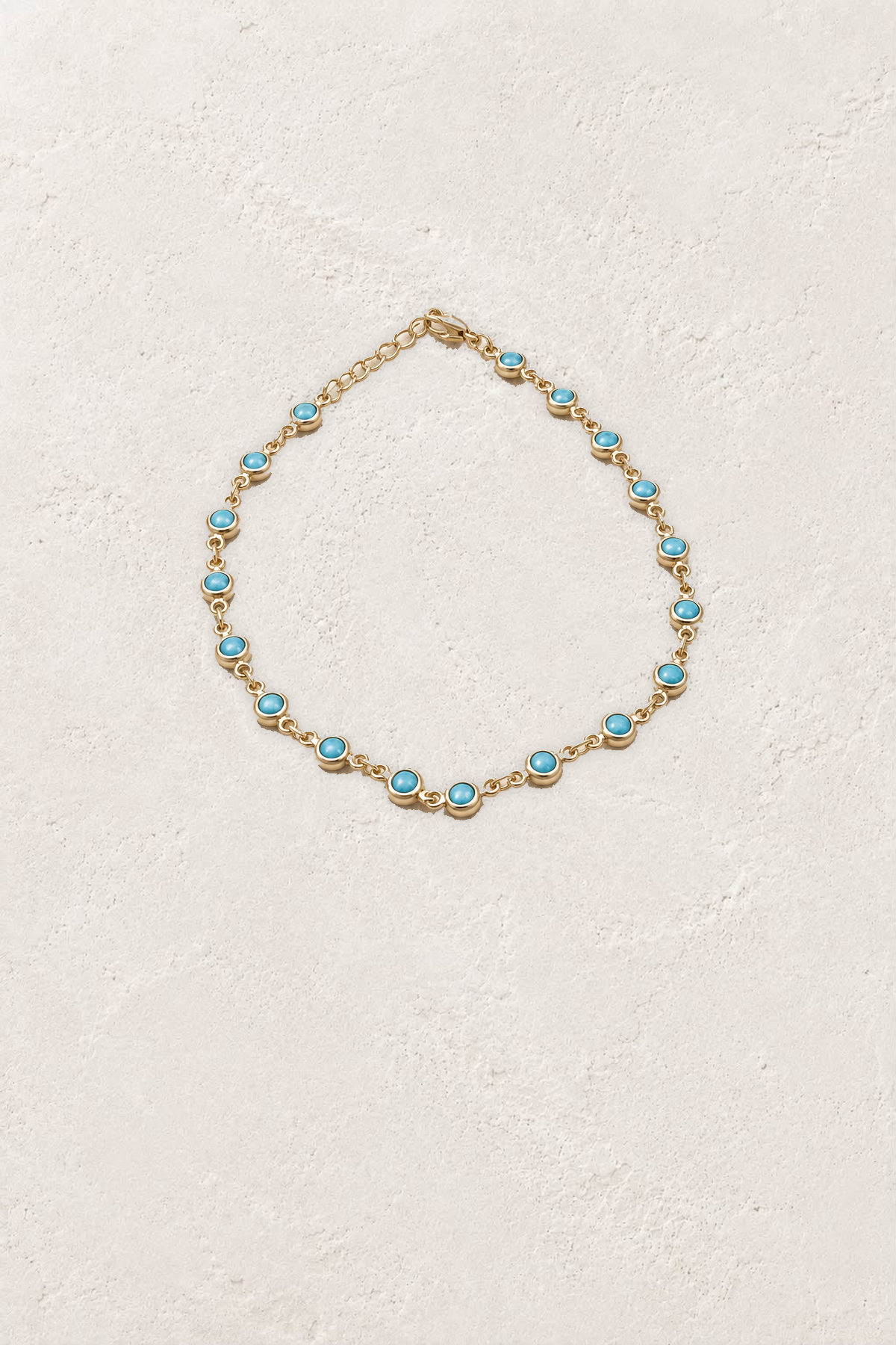 Turquoise gold chain bracelet on Boho & Mala's off-white plaster background
