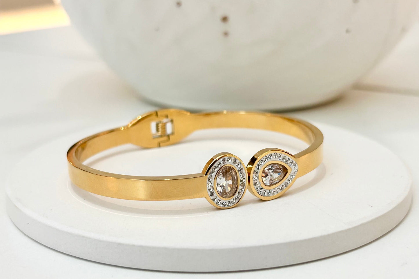 
                  
                    Seraphine Gold Pavé Halo Crystal Bangle displayed on a white stand
                  
                