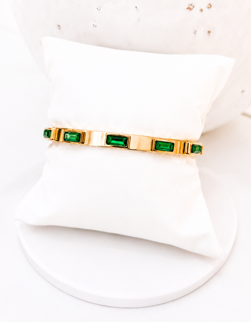 
                  
                    Emerelle Green Crystal Gold Bangle displayed on a white stand
                  
                