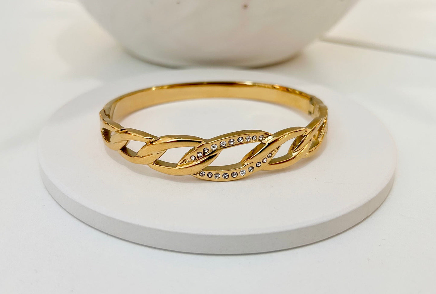 
                  
                    Celeste Gold Crystal Link Bangle displayed on a white stand
                  
                