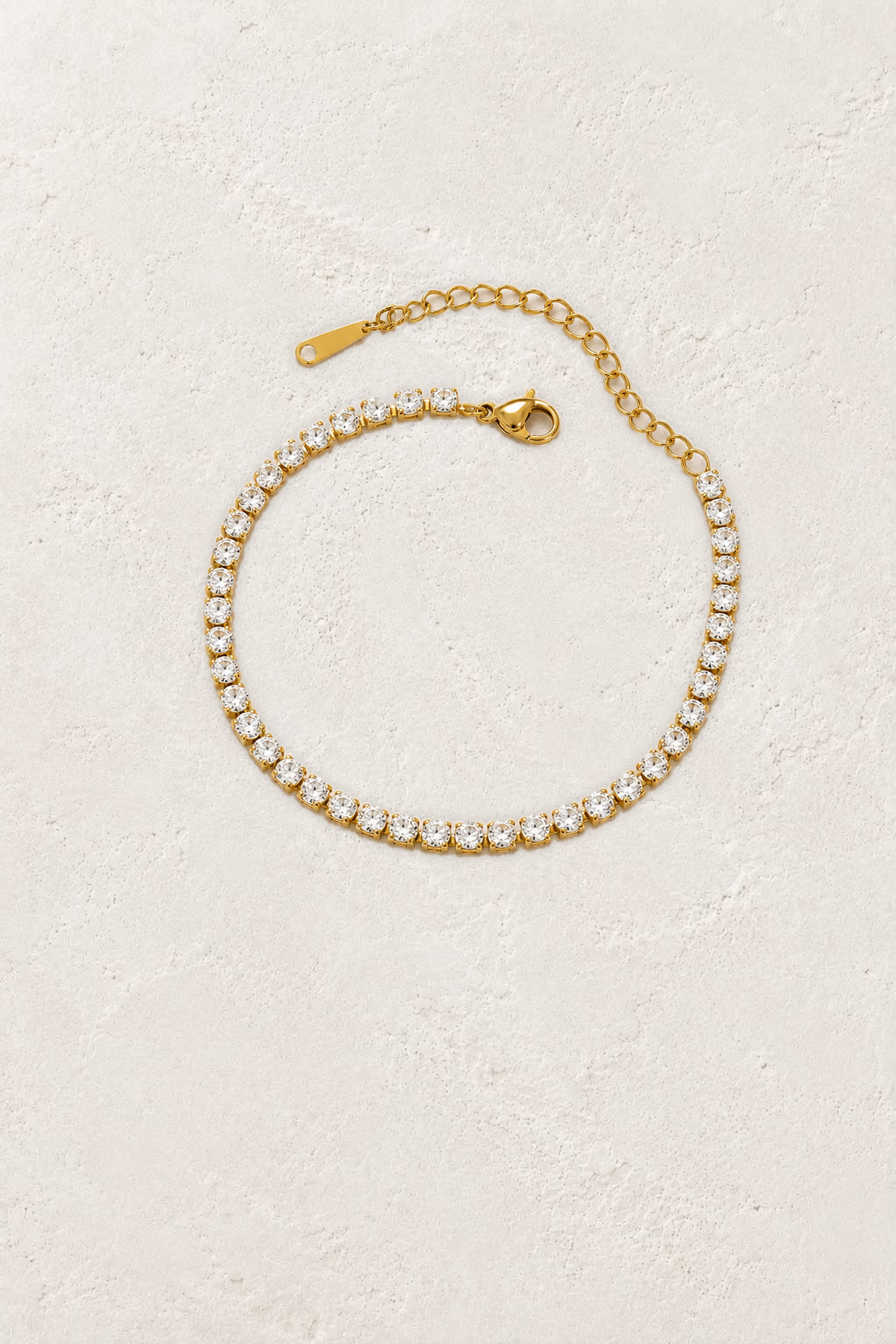 Aurelle Fine Gold Crystal Tennis Bracelet on the reference plaster background