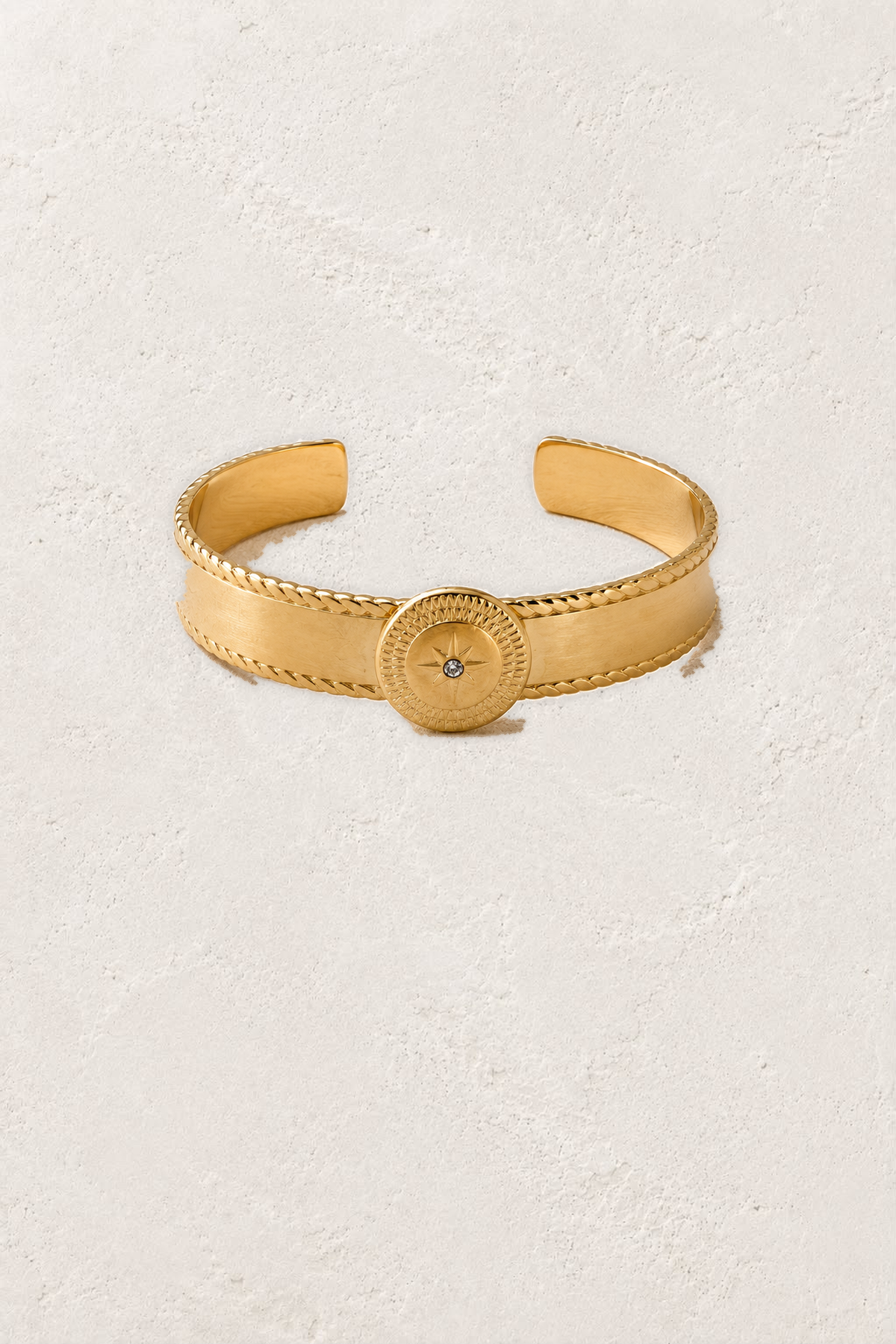 
                  
                    Asterelle Brushed Gold Sun Medallion Cuff on the reference plaster background
                  
                