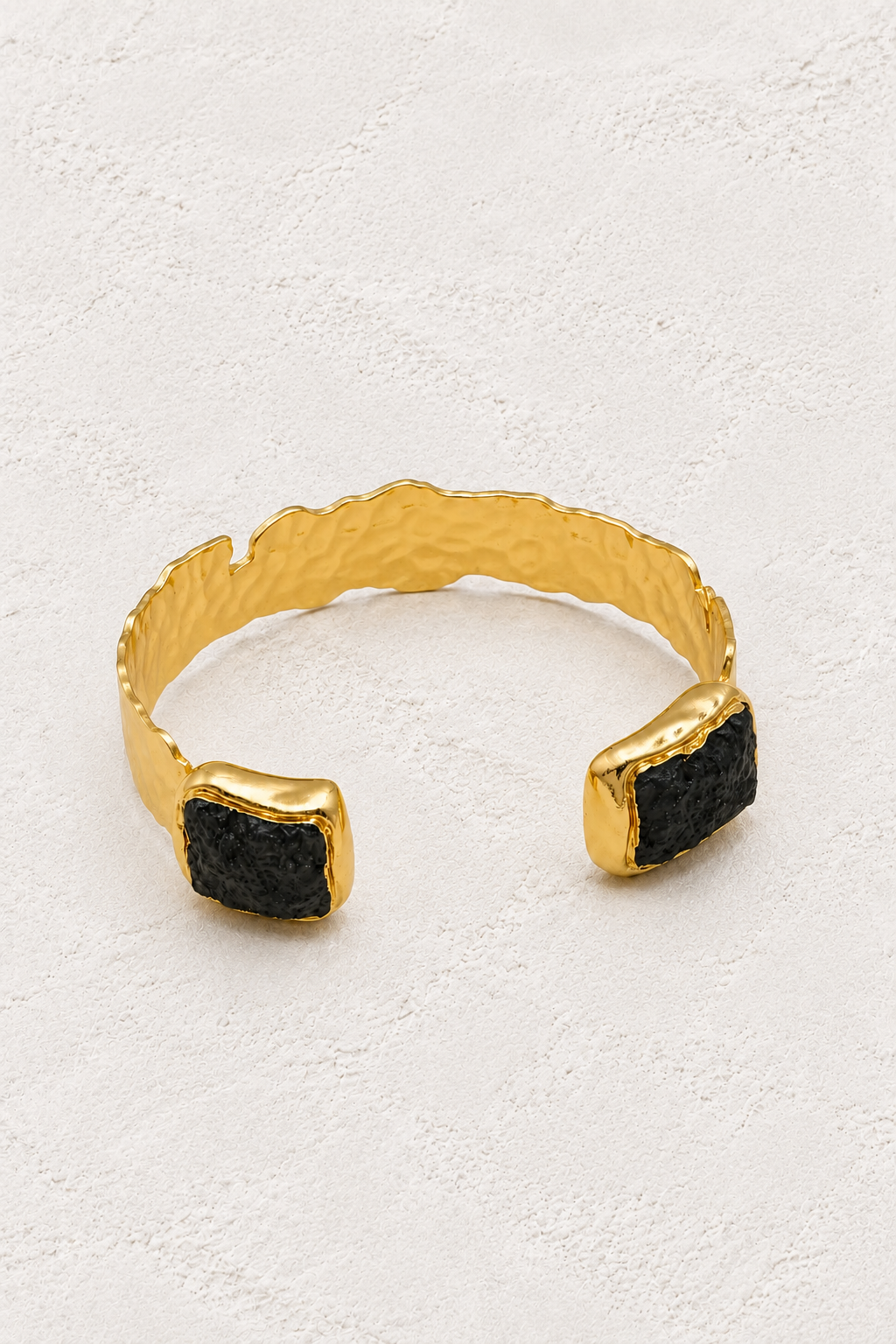 Coralia Black Lava Stone Cuff on warm ivory plaster