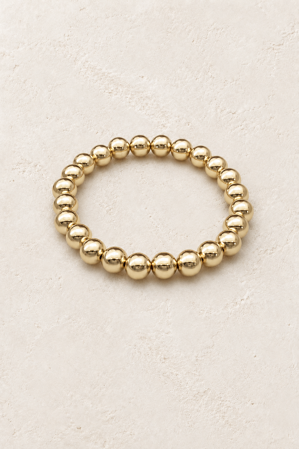 
                  
                    8mm Gold Plated Beaded Elastic Bracelet TF on Boho & Mala's cream beige textured hero background
                  
                