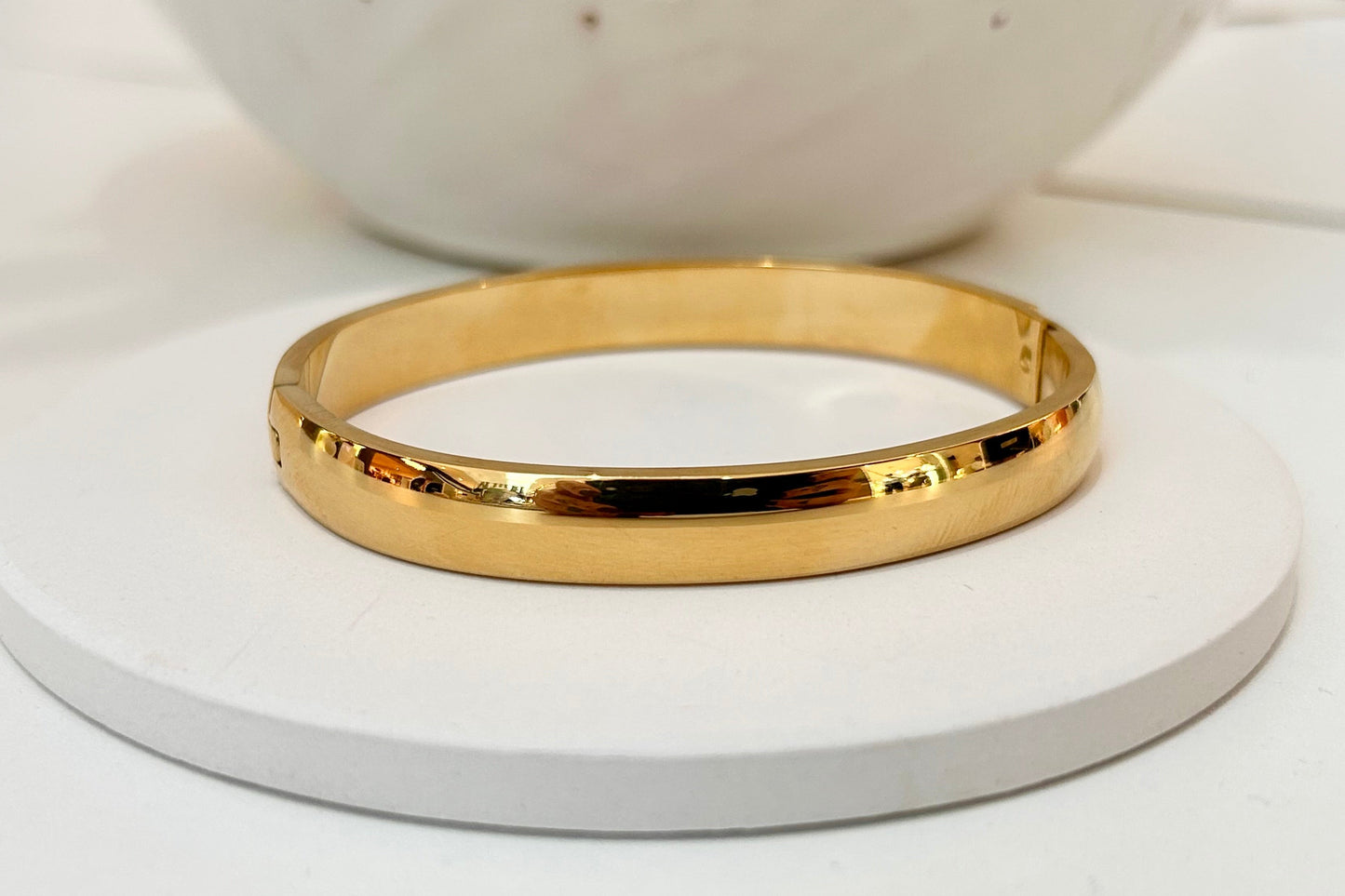 
                  
                    Marvelle Classic Rounded Gold Bangle displayed on a white stand
                  
                