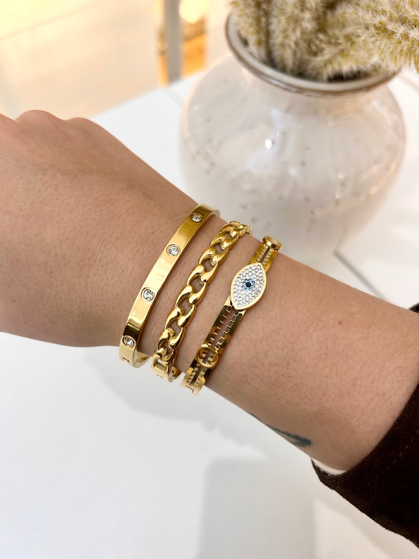 
                  
                    Stack of Boho & Mala waterproof gold bangles worn on a model's wrist
                  
                