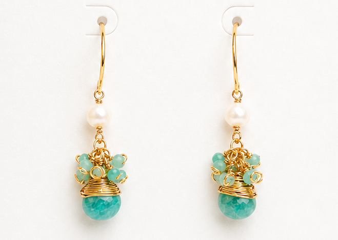 
                  
                    Pair of gold earrings with turquoise stones on a BOHO & MALA branded card.
                  
                