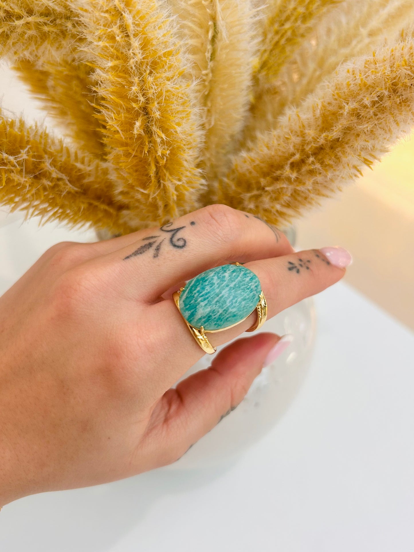 
                  
                    Aurevia Amazonite Statement Ring featuring a natural aqua-blue oval gemstone with white marbling set in a sculptural tarnish-free gold-plated band.
                  
                