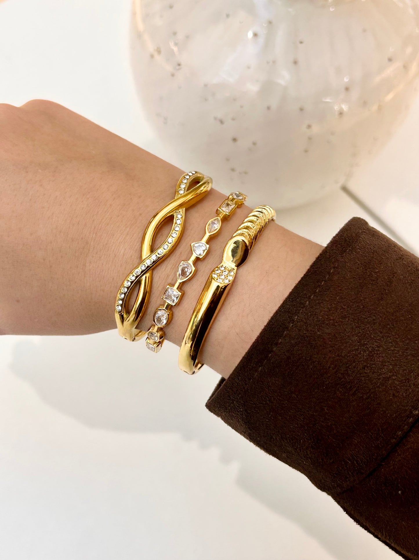 
                  
                    Stack of Boho & Mala waterproof gold bangles worn on a model's wrist
                  
                