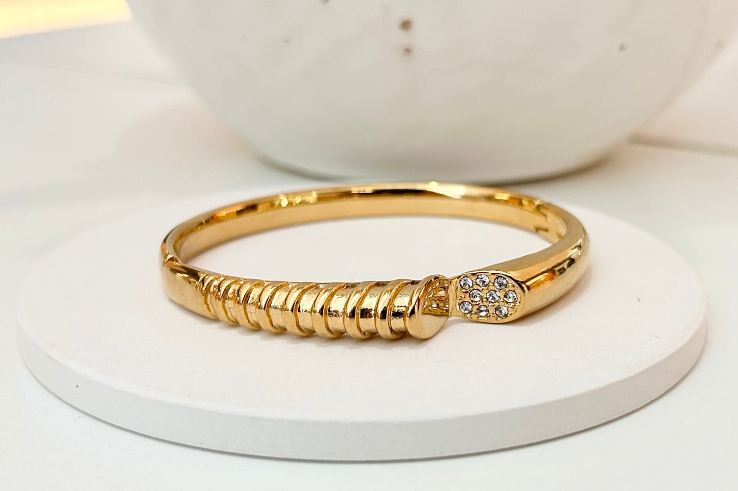 
                  
                    Sabine Sculptural Gold Pavé Bangle displayed on a white stand
                  
                