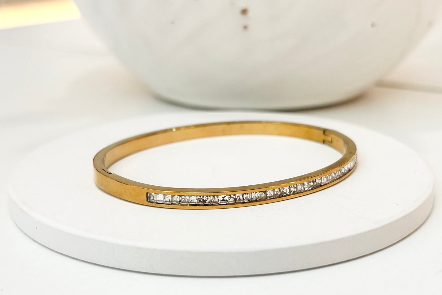 
                  
                    Roselle Gold Princess-Cut Crystal Bangle displayed on a white stand
                  
                