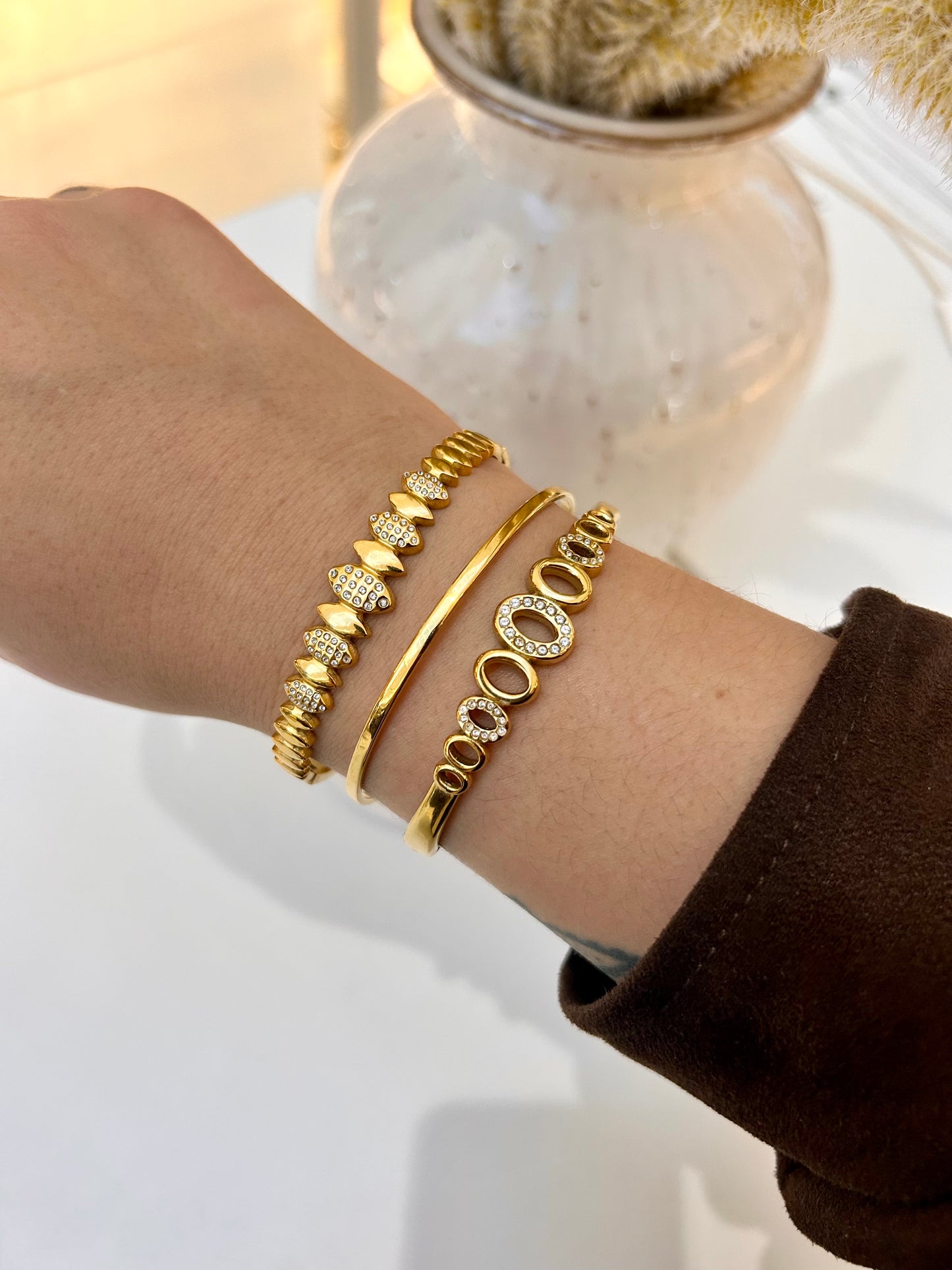 
                  
                    Stack of Boho & Mala waterproof gold bangles worn on a model's wrist
                  
                