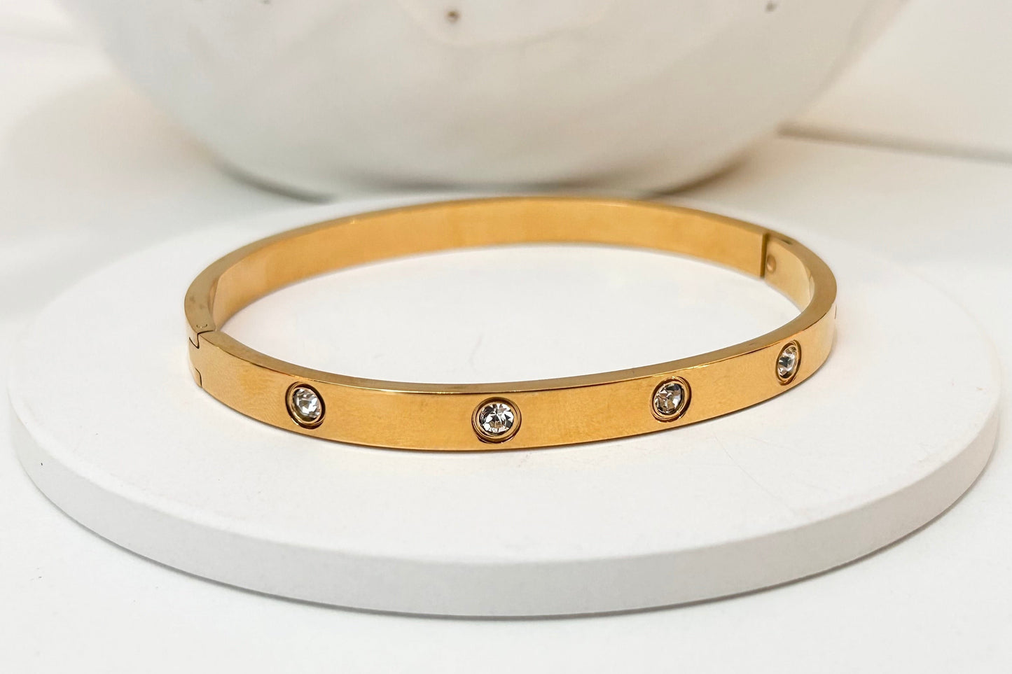
                  
                    Lunara Gold Crystal Bangle displayed on a white stand
                  
                