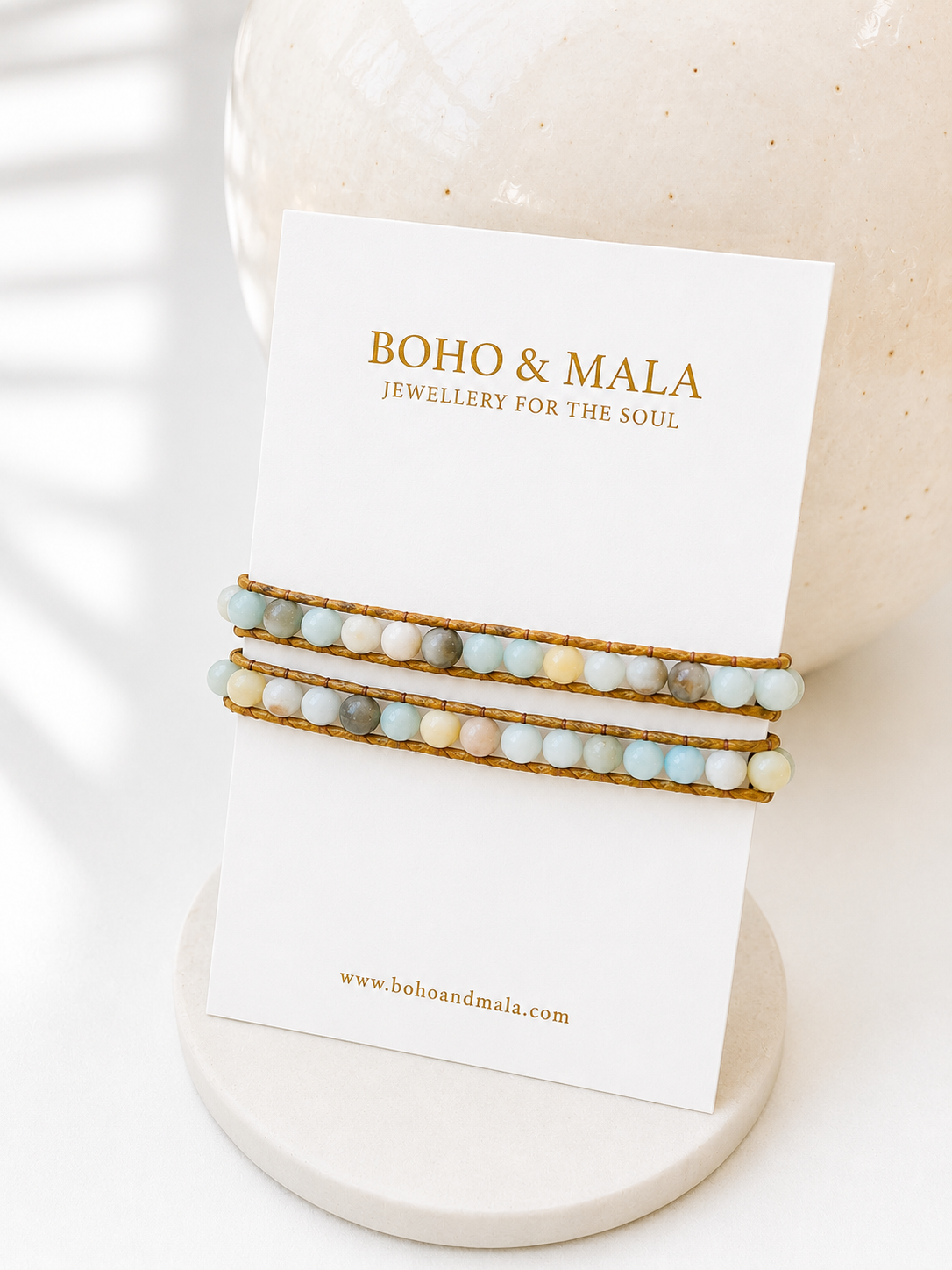 
                  
                    Two wrap amazonite beige beaded bracelets on a 'Boho & Mala' branded card with a candle in the background.
                  
                