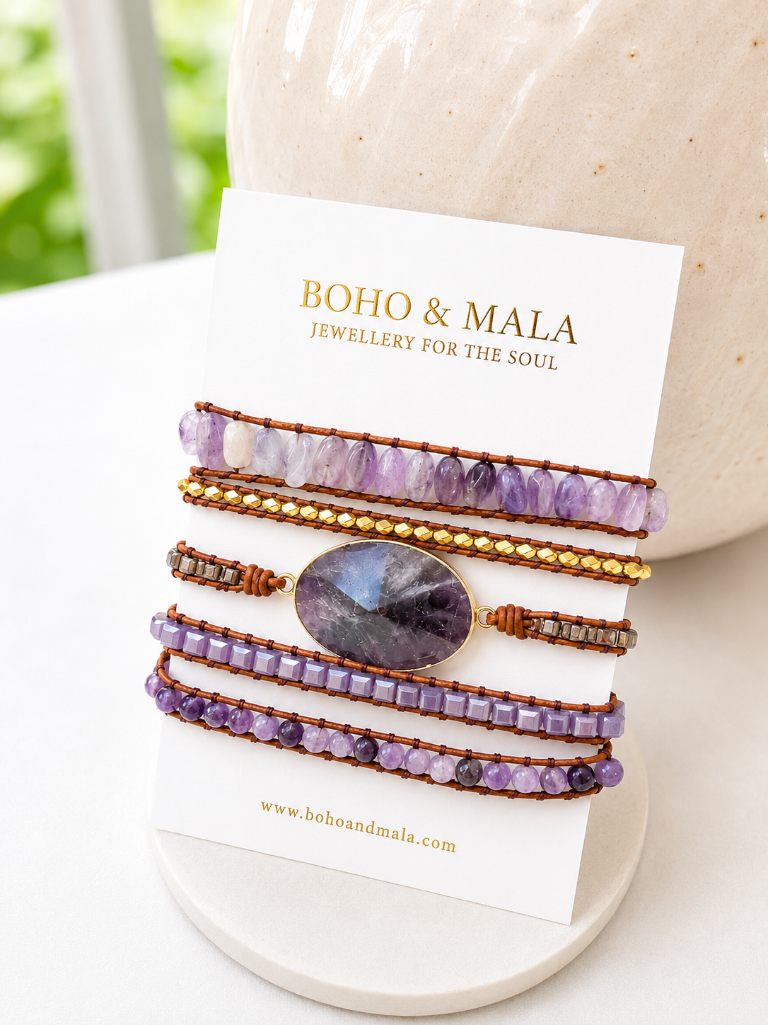 
                  
                    Set of beaded bracelets on a 'Boho & Mala' branded card with a blurred natural background.
                  
                