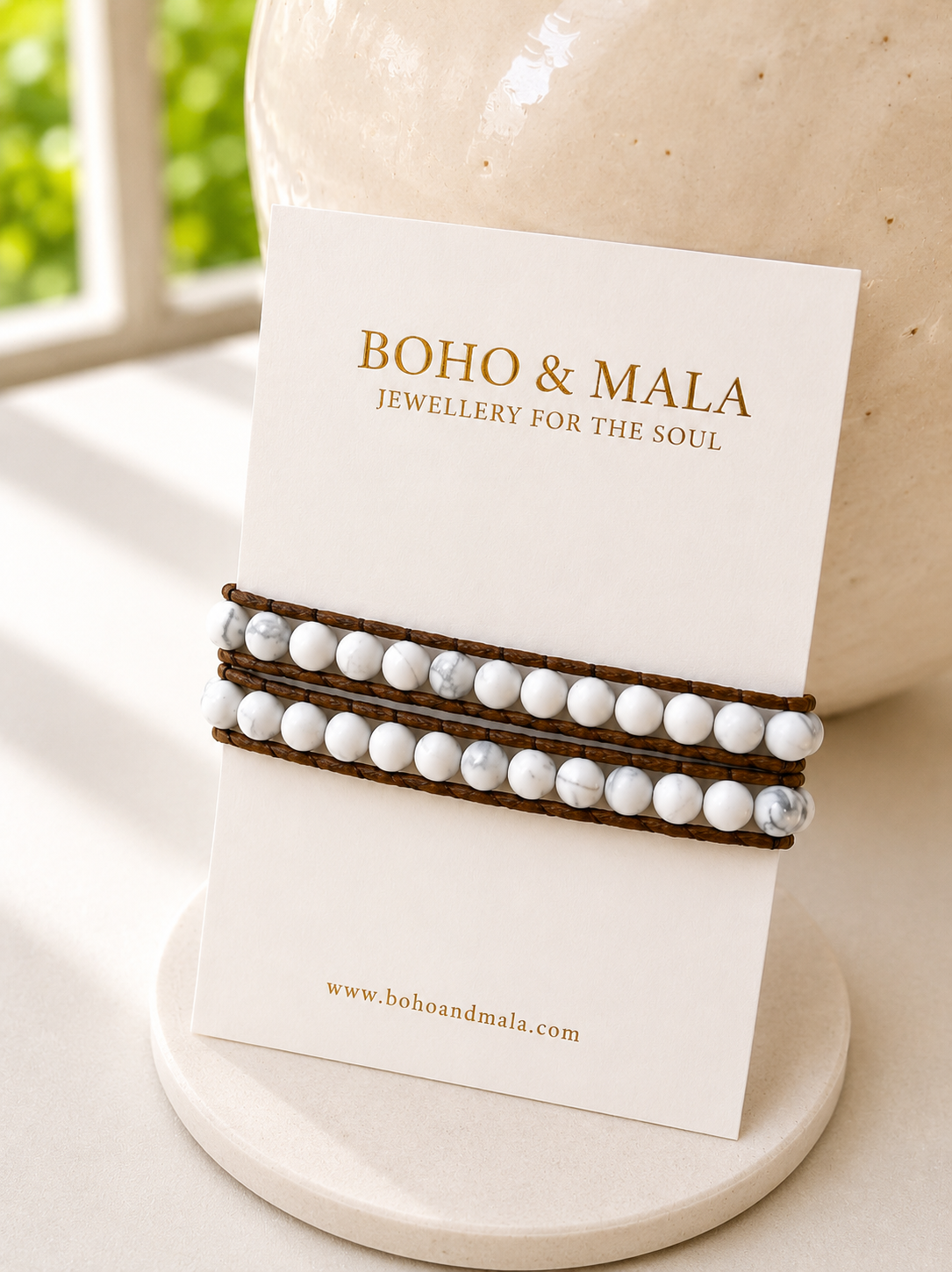 
                  
                    Two beaded white howlite bracelets on a card with 'Boho & Mala' branding.
                  
                