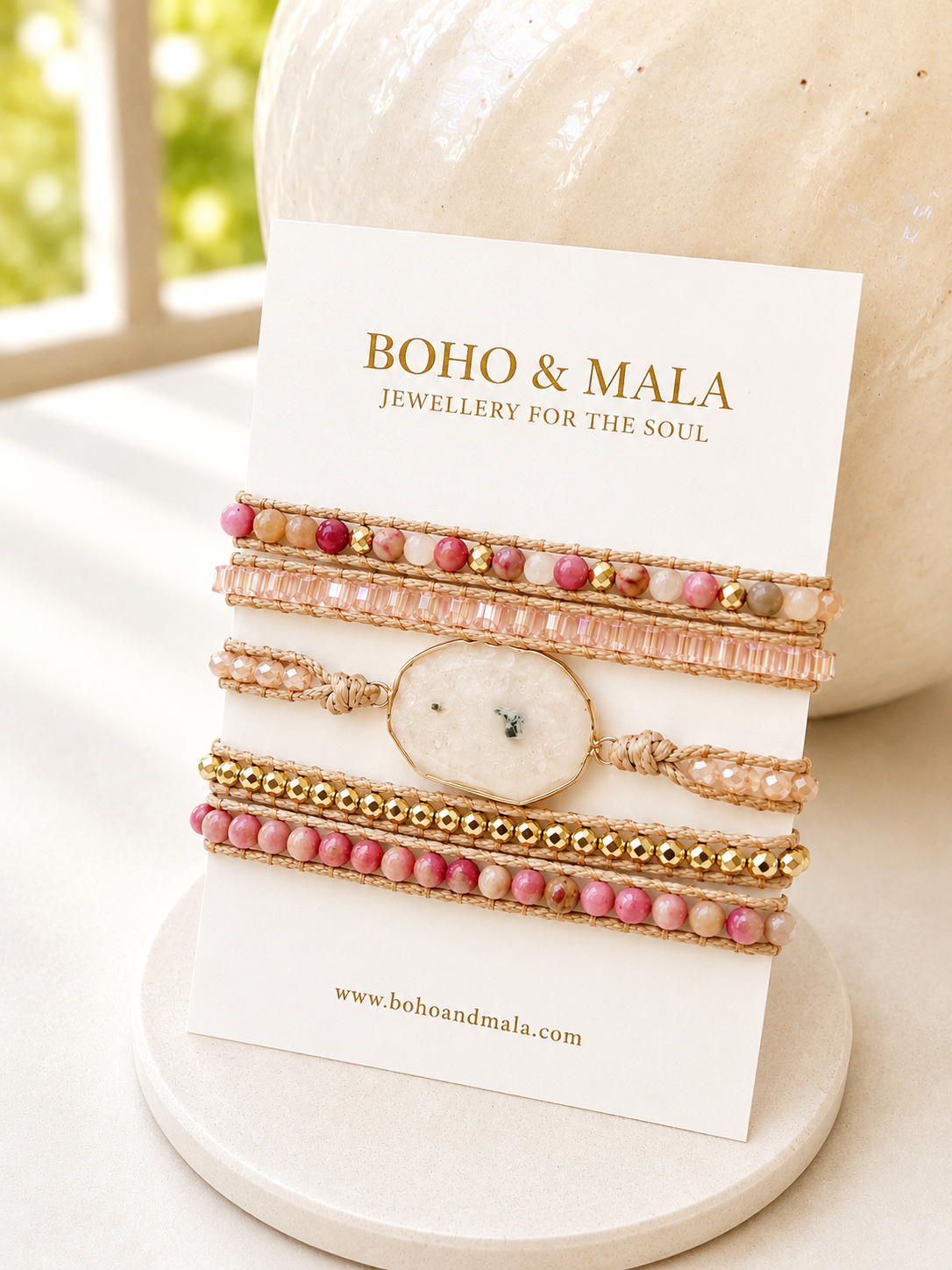 
                  
                    Set of beaded white agate and pink rhodonite wrap bracelets on a white card with 'Boho & Mala' branding.
                  
                