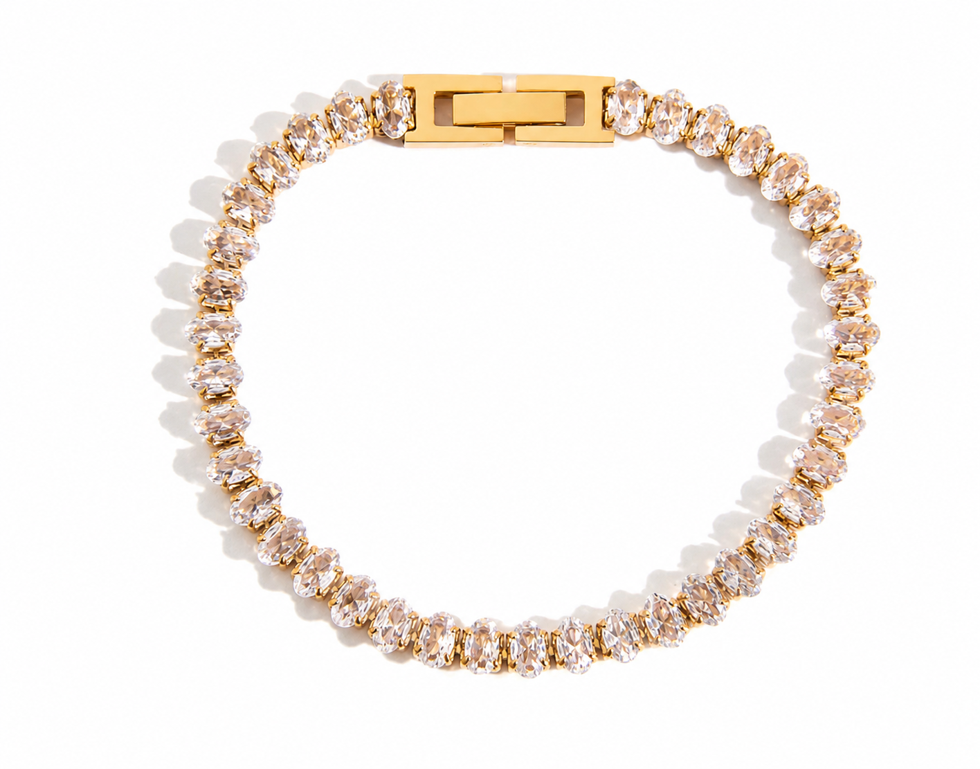 
                  
                    Aurora Oval Crystal Gold Tennis Bracelet displayed on a white stand
                  
                