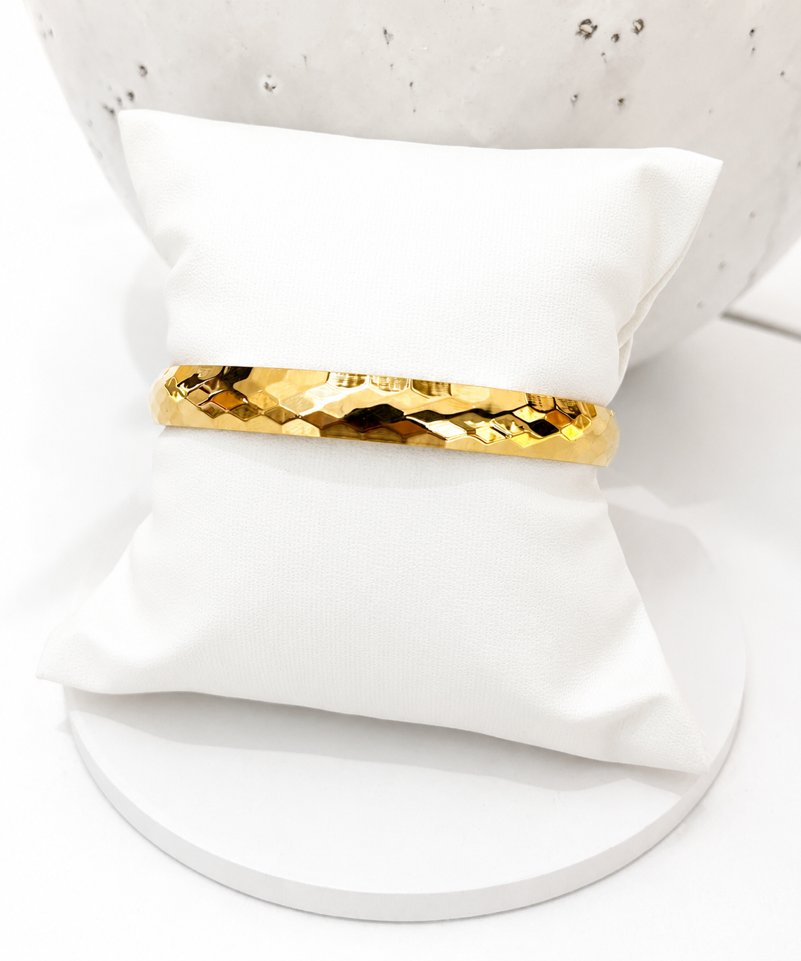 
                  
                    Valenza Hammered Gold Bangle displayed on a white stand
                  
                