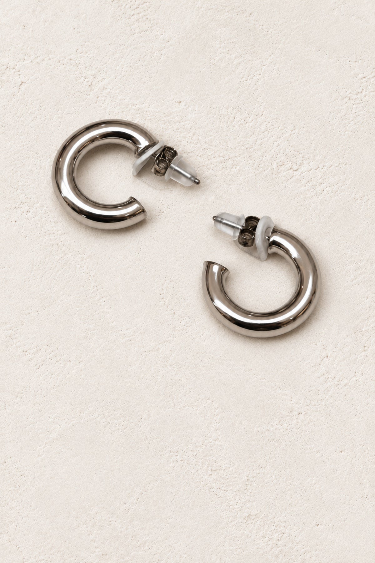 
                  
                    Alba Silver Chunky Hoop Earrings - Sterling Silver on warm ivory plaster
                  
                