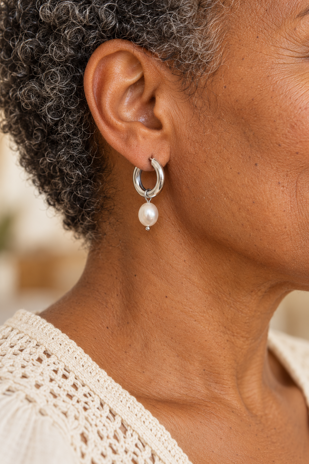 
                  
                    Close-up of Alondra Silver Pearl Drop Hoop Earrings worn on a boho chic model
                  
                