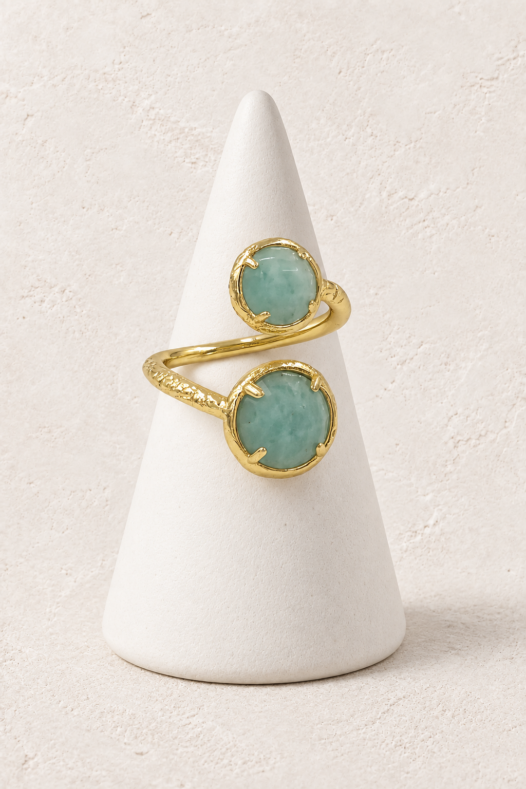 Amara Double Amazonite Ring on a white display cone against a warm textured background