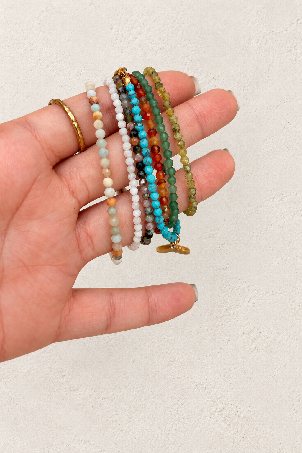 
                  
                    Anaya Gold Natural Stone Beaded Bracelet on warm ivory plaster background
                  
                