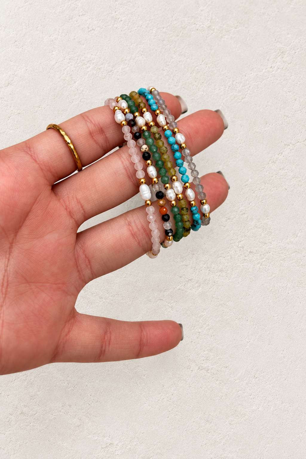 
                  
                    Anaya Gold Pearl & Natural Stone Beaded Bracelet on warm ivory plaster background
                  
                