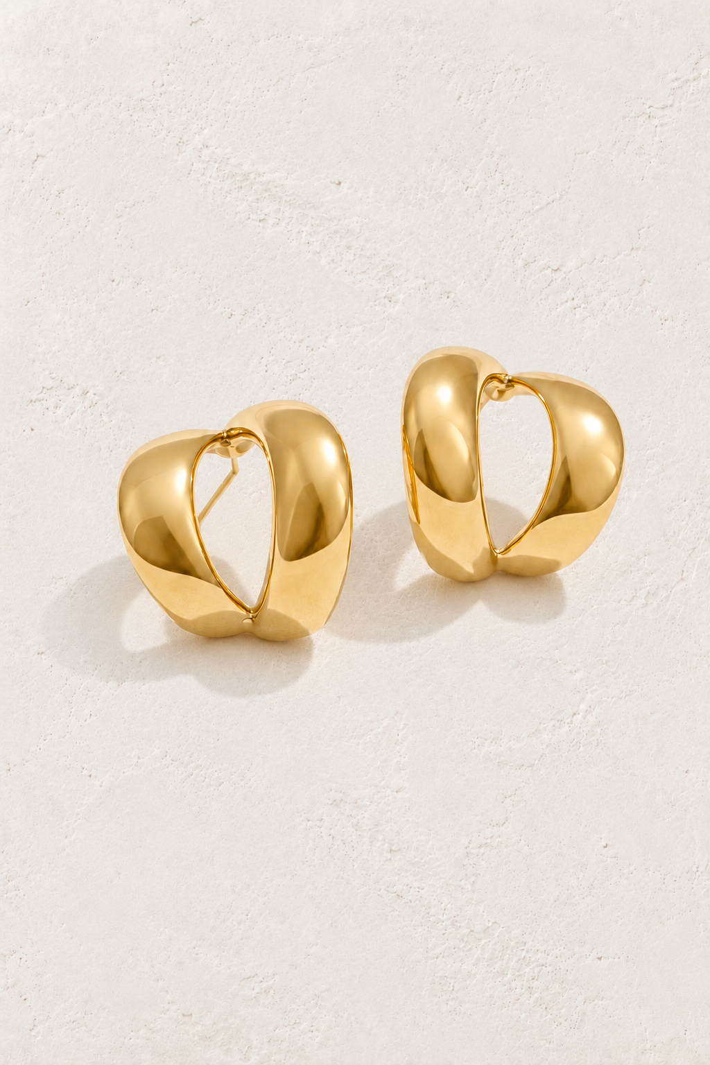 
                  
                    Gold sculptural teardrop hoops on approved cream hero background
                  
                