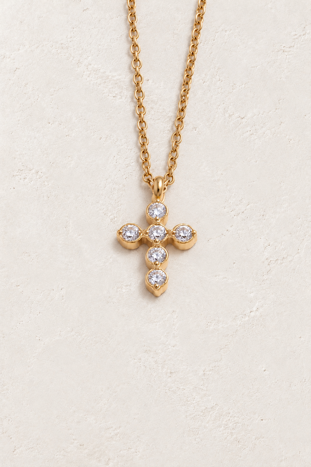
                  
                    Gold zircon cross necklace on approved cream hero background background
                  
                