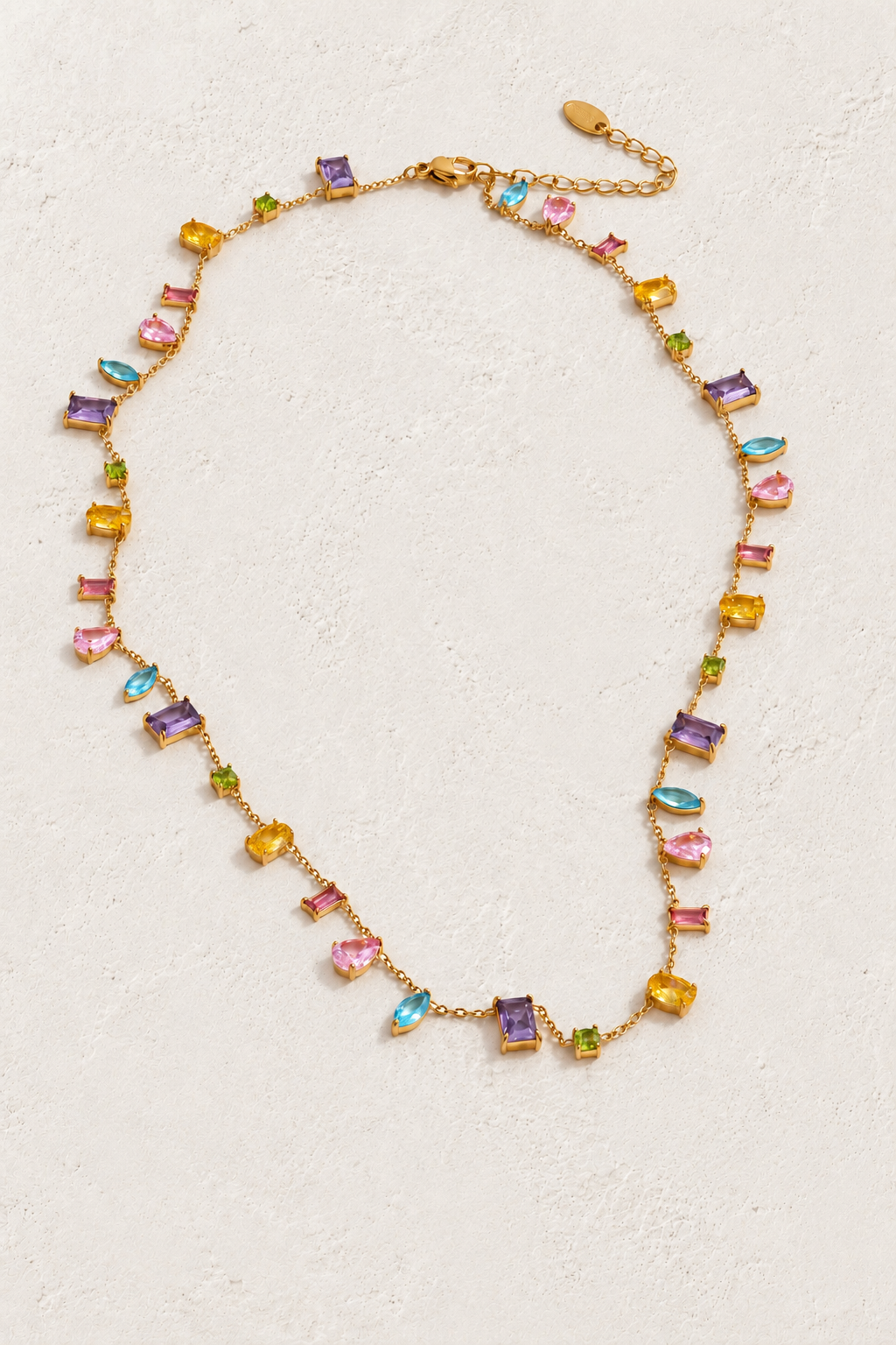 
                  
                    Gold mixed-cut multicolour cubic zirconia necklace on approved cream hero background
                  
                