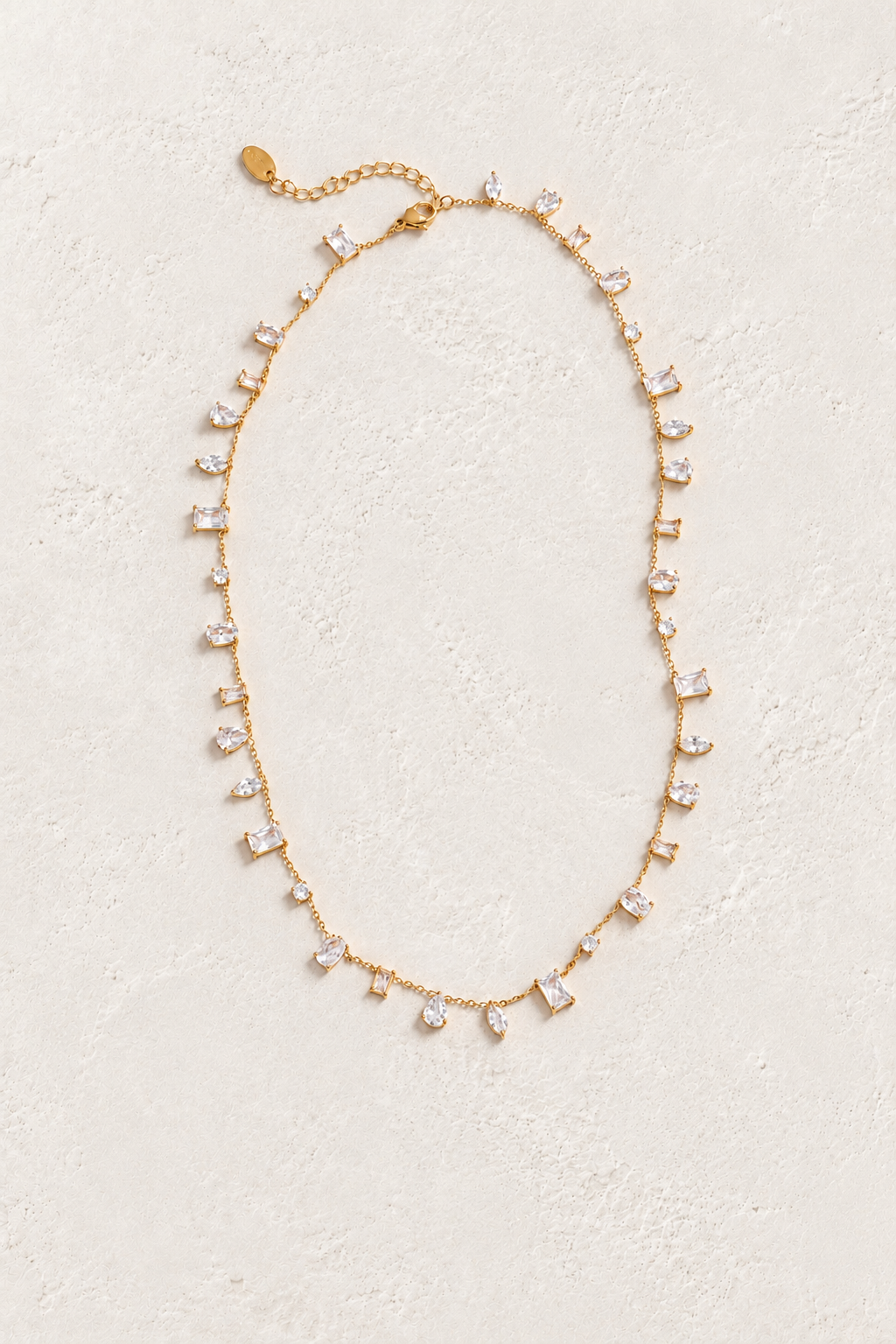 
                  
                    Gold clear cubic zirconia necklace on approved cream hero background
                  
                
