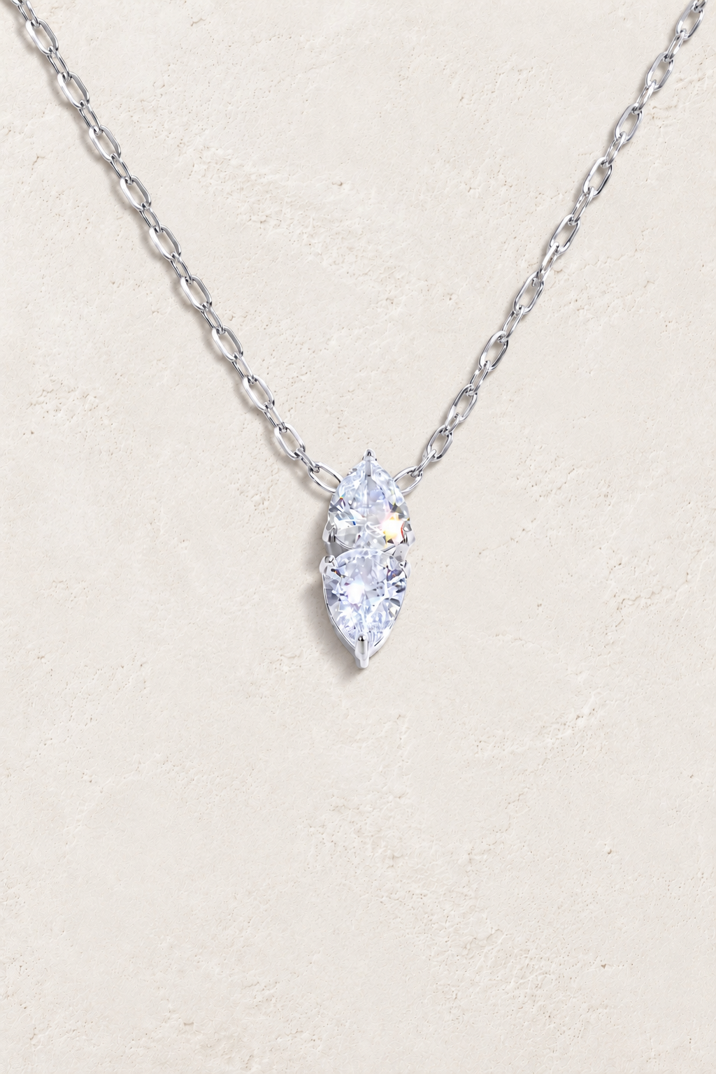 
                  
                    Silver double teardrop cubic zirconia necklace on approved cream hero background
                  
                