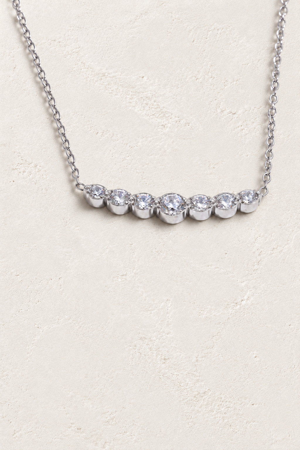 
                  
                    Silver seven-stone cubic zirconia necklace on approved cream hero background
                  
                