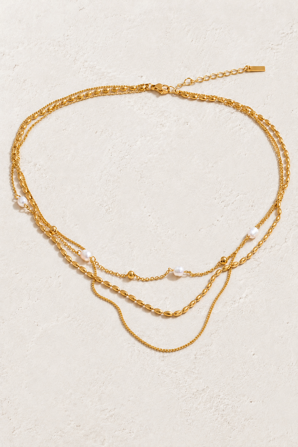 
                  
                    Triple Layer Natural Pearl Chain Necklace on approved cream hero background
                  
                