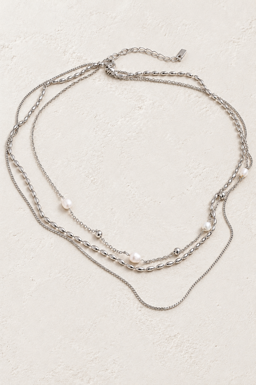 
                  
                    Silver Triple Layer Natural Pearl Chain Necklace on approved cream hero background
                  
                