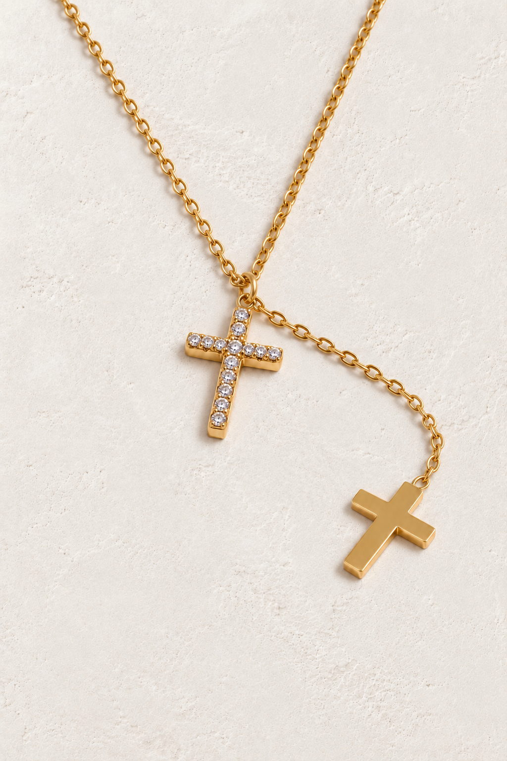 
                  
                    Gold double cross necklace on approved cream hero background
                  
                