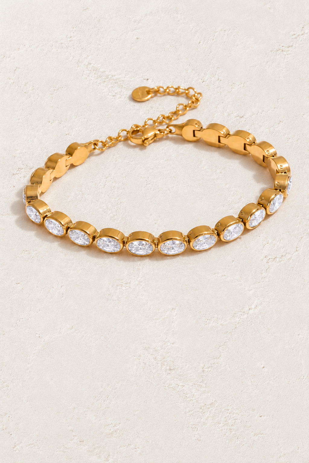 
                  
                    Oval bezel gold bracelet on approved cream hero background
                  
                