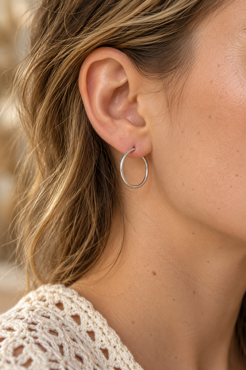 
                  
                    Close-up of Arlette Silver Slim Hoop Earrings worn on a boho chic model
                  
                
