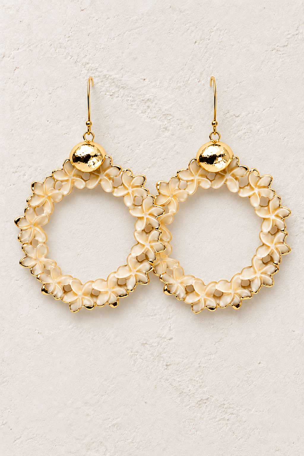 
                  
                    Aurelia Bloom floral statement earrings on a warm textured background
                  
                